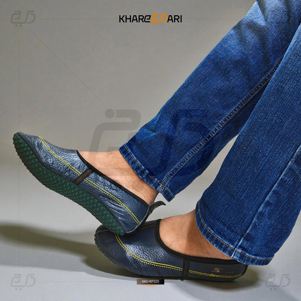 Blue leather shoes with yellow stitching worn with blue jeans on a gray background, featuring the brand 'Khareebari'. Purple