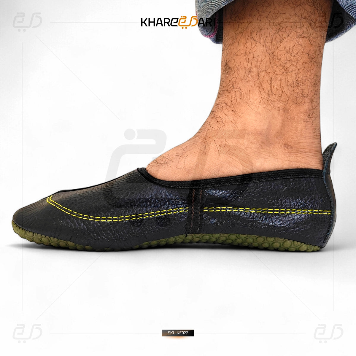 Black slip-on shoe with yellow stitching on a white background Black