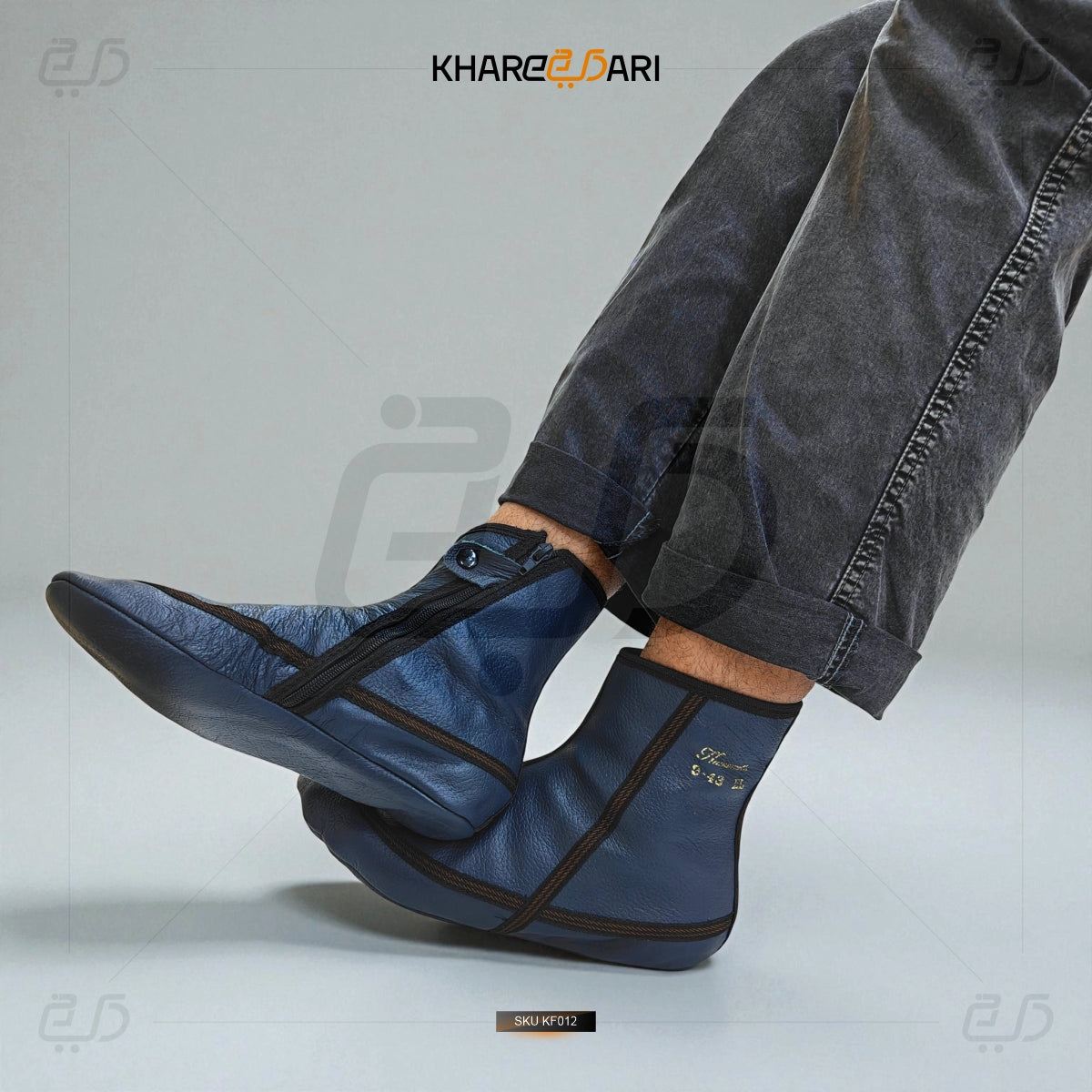 Blue ankle boots with black accents worn by a person, on a gray background with 'Khareeb Dari' branding. Blue
