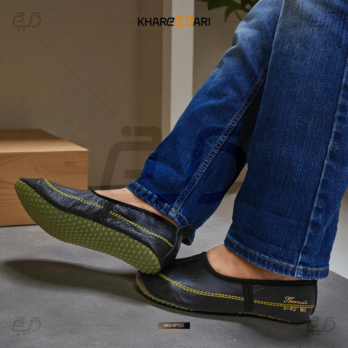 Person wearing black shoes with green soles and blue jeans, standing on a gray surface. Purple