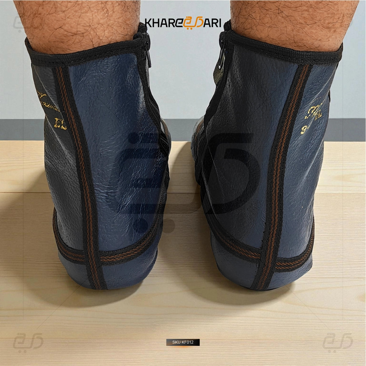 Blue protective shin guards with black accents on a wooden floor, brand 'Khareebari' visible. Blue