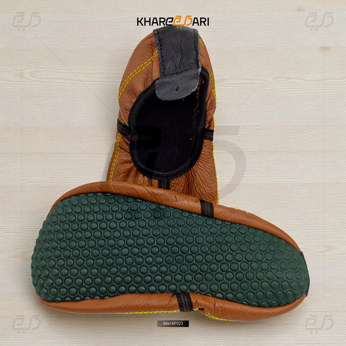 Brown and black shoe with green sole on a light wooden surface, branded 'KharbeDari'. Brown