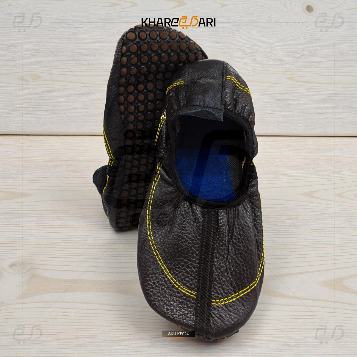 Black slip-on shoes with textured sole on a light wooden surface, branded 'Khareebari'. Dark Brown